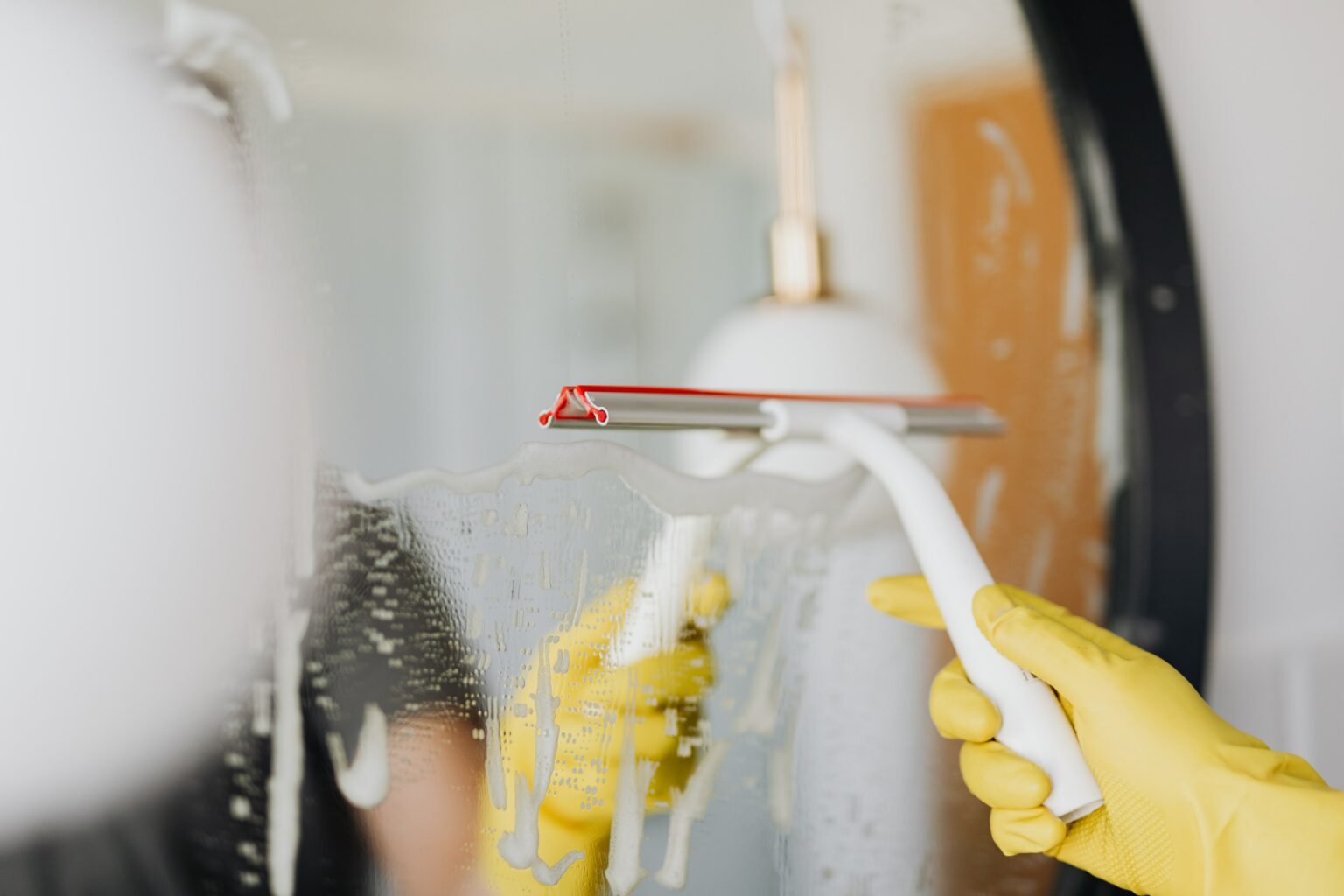 Professional cleaner washing a glass surface